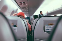 Sitting in an airplane seat as people board their flight. Original public domain image from Wikimedia Commons