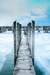 A narrow wooden footbridge extends across a frozen lake. Original public domain image from <a href="https://commons.wikimedia.org/wiki/File:Lexington_(Unsplash).jpg" target="_blank" rel="noopener noreferrer nofollow">Wikimedia Commons</a>