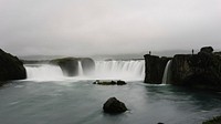 A gray image capturing two waterfalls streaming into a pool of water. Original public domain image from Wikimedia Commons