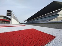 Ground-level view of the race track and the sitting area of the Algarve International Circuit.. Original public domain image from <a href="https://commons.wikimedia.org/wiki/File:Algarve_International_Circuit_(Unsplash).jpg" target="_blank" rel="noopener noreferrer nofollow">Wikimedia Commons</a>