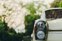 Cropped shot of a white vintage car's lights.. Original public domain image from Wikimedia Commons