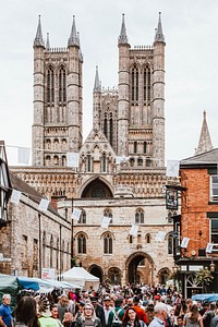 The streets filled with people in front of a cathedral church. Original public domain image from Wikimedia Commons