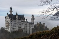 Orante Neuschwanstein Castle surrounded by fog and woods. Original public domain image from Wikimedia Commons
