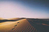 Footsteps and ripples in the sand dunes of Gobabeb and a clear pale blue sky. Original public domain image from Wikimedia Commons