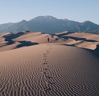 Hiker leaves trail of footprints in the rippling sand of the desert. Original public domain image from Wikimedia Commons