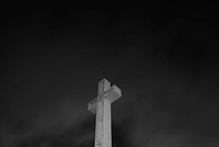 Black and white shot of white cross on Soledad Mountain on dark sky background. Original public domain image from Wikimedia Commons