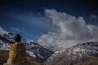 Sitting buddha overlooking open mountains and land with clouds above. Original public domain image from Wikimedia Commons