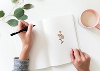 Woman drawing doodle elements in a notebook