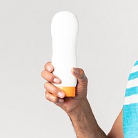 Senior African American man holding a sunscreen lotion bottle