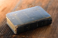 Free old closed book on wooden table photo, public domain CC0 image.