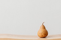Brown pear on a wooden bench in a white room