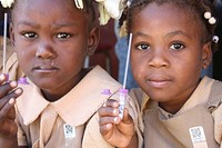 Children holding vaccination tube waiting to get vaccinated.