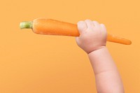 Baby hand holding big carrot image