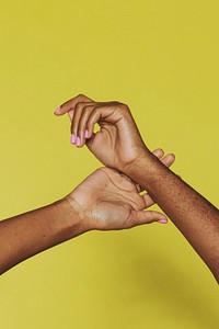 Black female hands on a yellow background 