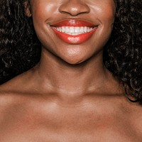 Happy black woman wearing a peach lip gloss