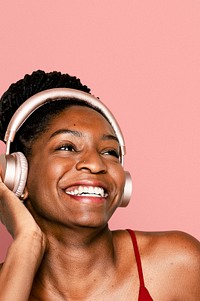 Cheerful woman listening to music through headphones digital device