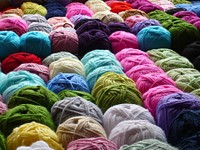 Image of multiple rolls of wool yarn in varied colors that are in no particular order. Original public domain image from Wikimedia Commons