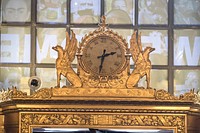 Gilded clock above a door inside the Cleveland Public Library's main building in Cleveland, Ohio.  Construction of the classical Renaissance building, designed by the Walker and Weeks firm, delayed by the First World War, began in 1923 under Linda Anne Eastman.