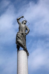 Fishermen's Memorial at Fishermen's Terminal docks in Seattle, Washington.  The towering sculpture and its bronze name plates below remember commercial fishermen and women who died at sea. Many of the boats moored behind the monument ply dangerous waters as far away as Alaska and bring back catches of wild salmon and other seafood to this large Pacific Northwest city.  