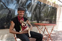 Frank Smith, a disabled World War II veteran who spends much of his time on the streets of Fort Worth, Texas, sits with his dog in front of the Aviation Wall of Honor in General Worth Square in downtown Fort Worth.