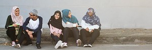Happy muslim women sitting together outdoors