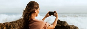 Woman taking photos of the sea