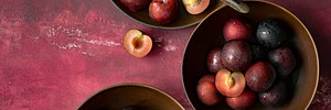 Red plums in a bowl summer food flatlay