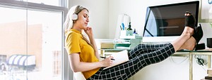 Casual woman in an office with headphones