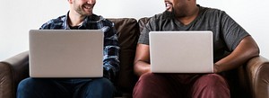 Men using laptop sitting on sofa