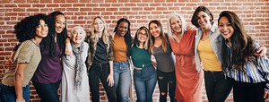 Diverse women standing together by a brick wall