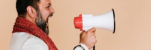 Indian man screaming into a megaphone 