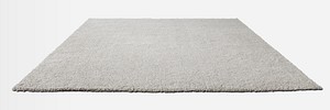 Gray fluffy floor carpet on off white background