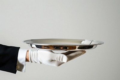 Silver tray being held by a hand service serving white.