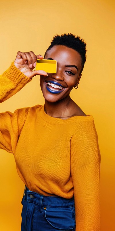 Black woman showing credit card happy background colors.