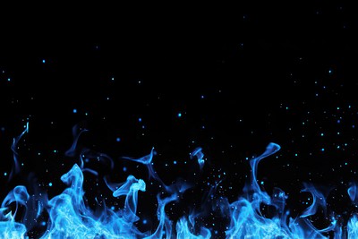 Real effect blue fire sparks background flames outdoors.