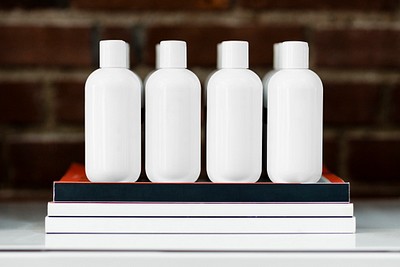 Four beauty product bottles on a shelf 