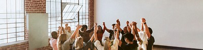 Group of diverse people holding hands up in the air