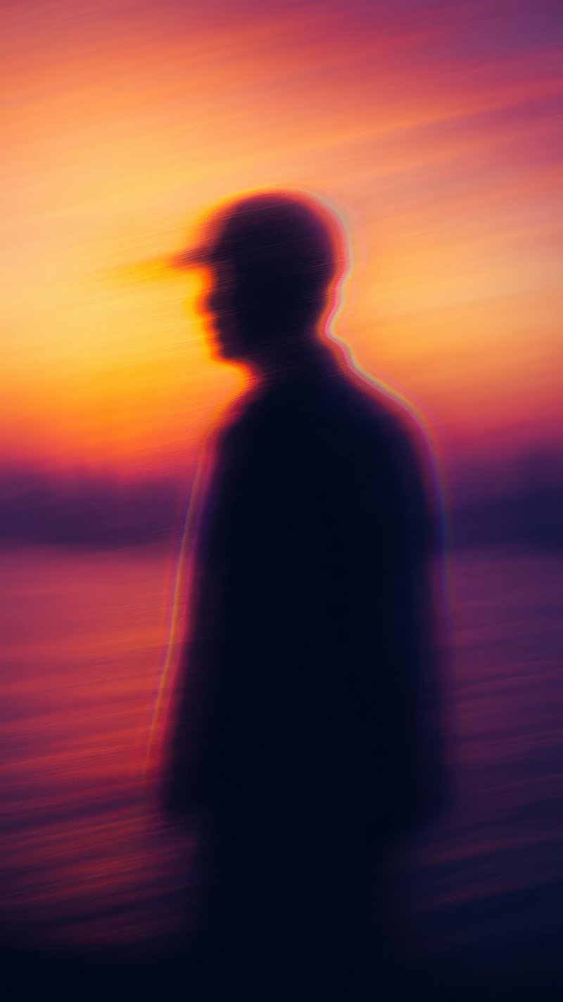 Silhouette against vibrant sunset.