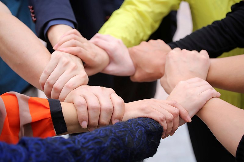 Premium Vector  Four hands hold each other by wrist join hands together  teamwork and friendship concept vector