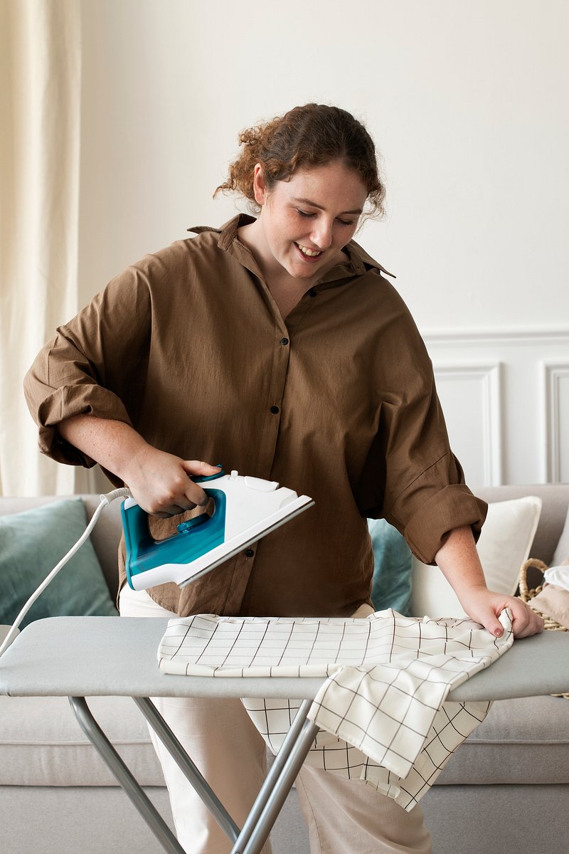 Premium Photo  A woman ironing a cloth on a ironing board