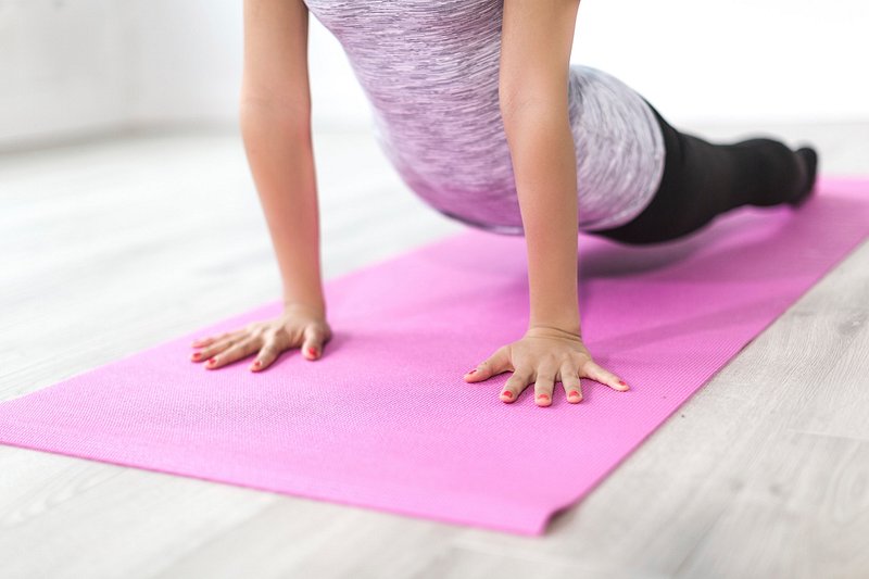 Middleaged Woman Practicing Yoga On A Powder Pink Yoga Mat On A