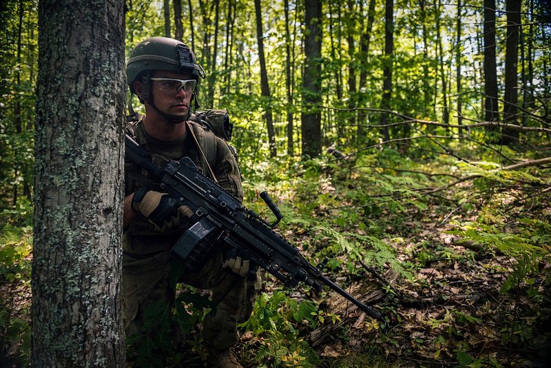 Premium Photo  Camouflaged sniper in the forest in ambush. military man  aiming a gun, a rifle at the enemy in nature