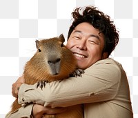 PNG Adult east asian man hugging capybara portrait animal mammal.