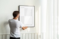 Picture frame png mockup, man decorating wall, transparent design