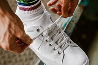 Man tying shoelaces on png canvas sneaker mockup