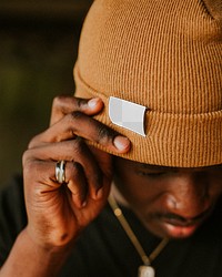 African American man wearing brown knit hat with png label