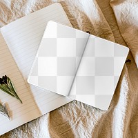 Open notebook png mockup with flowers on linen blanket