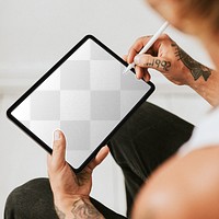 Tablet screen mockup png in the lap of a tattoed man