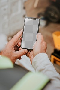 Man holding png smartphone mockup near a construction site