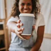 Paper coffee cup png mockup being held by a woman 